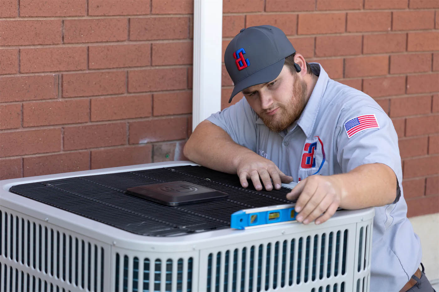 A Absolute Comfort Heating and Air Conditioning team memeber working on an HVAC system.