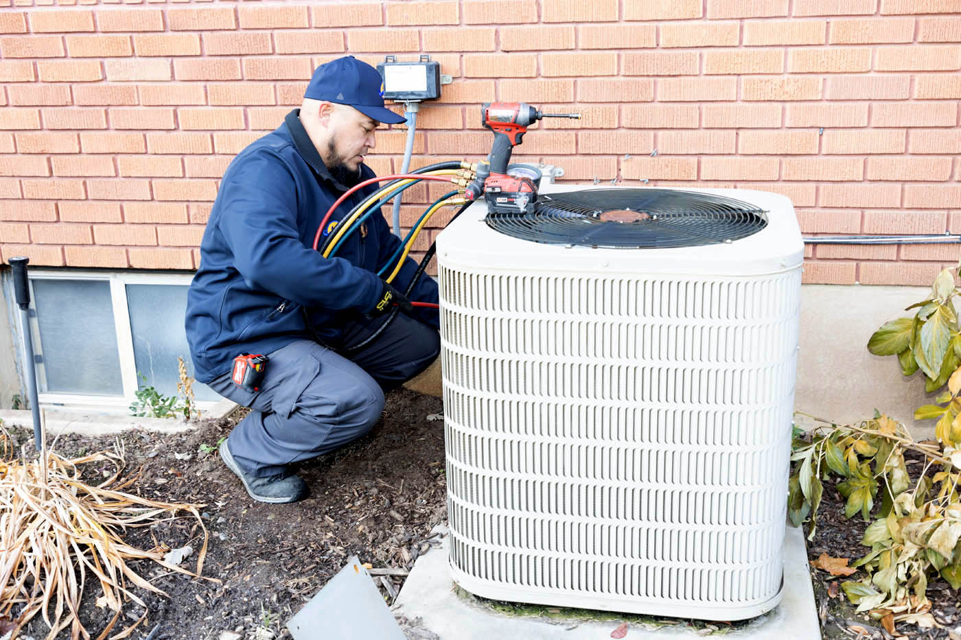 Absolute Comfort technicians working on an air conditioner unit - we almost always offer same-day air conditioning service repair.