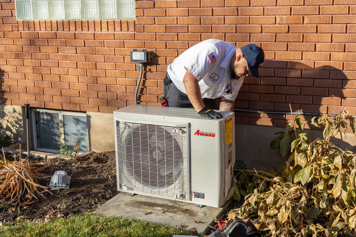A Absolute Comfort Heating and Air Conditioning expert installing a heat pump.