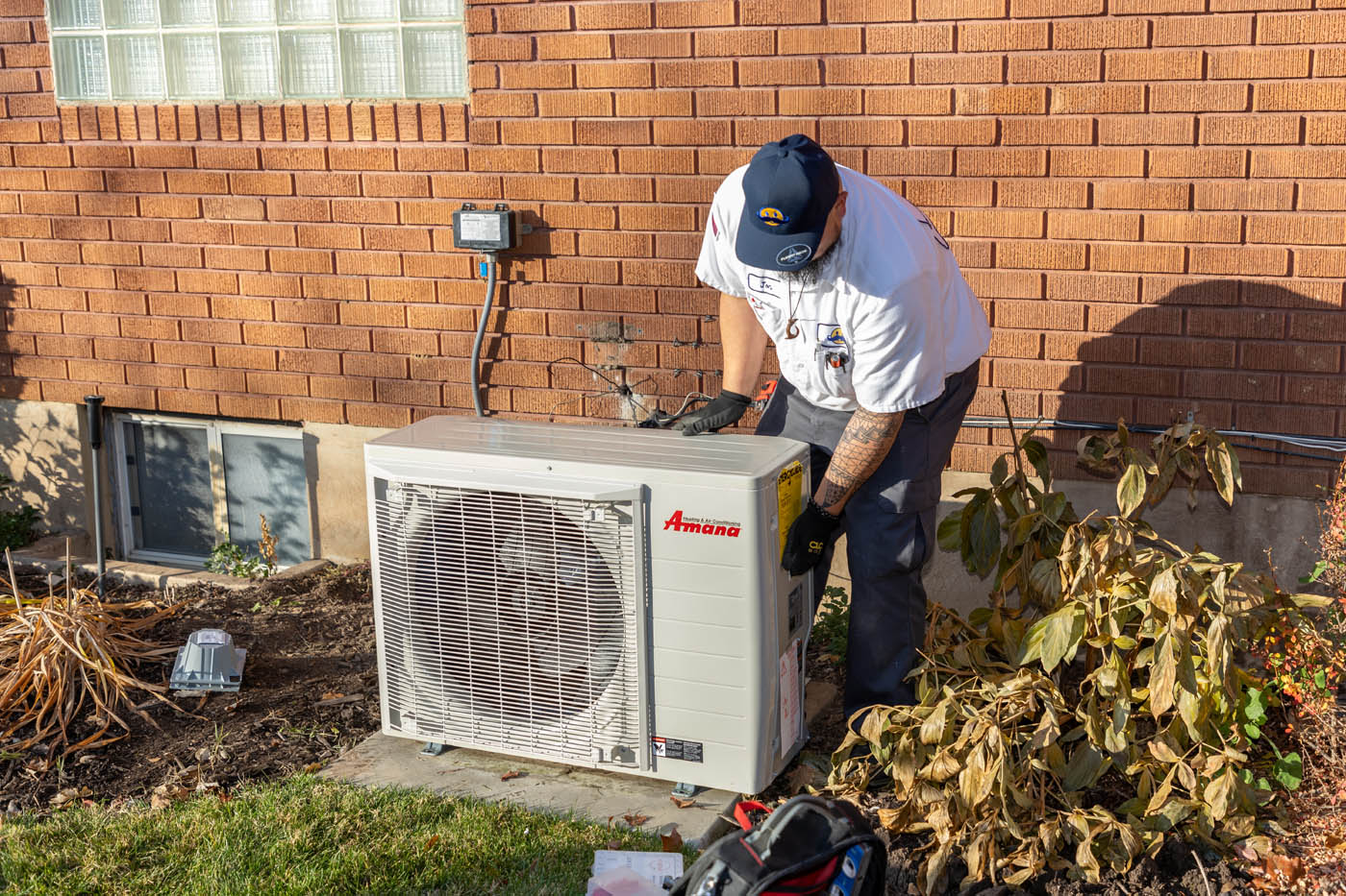 A Absolute Comfort Heating and Air Conditioning contractor installing a heat pump system.
