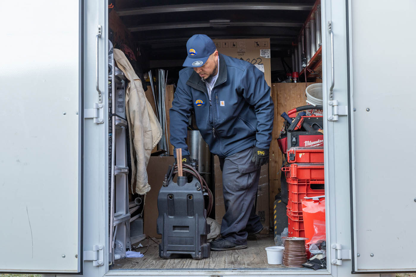 A Absolute Comfort Heating and Air Conditioning employee getting supplies and high-quality products from our service truck.