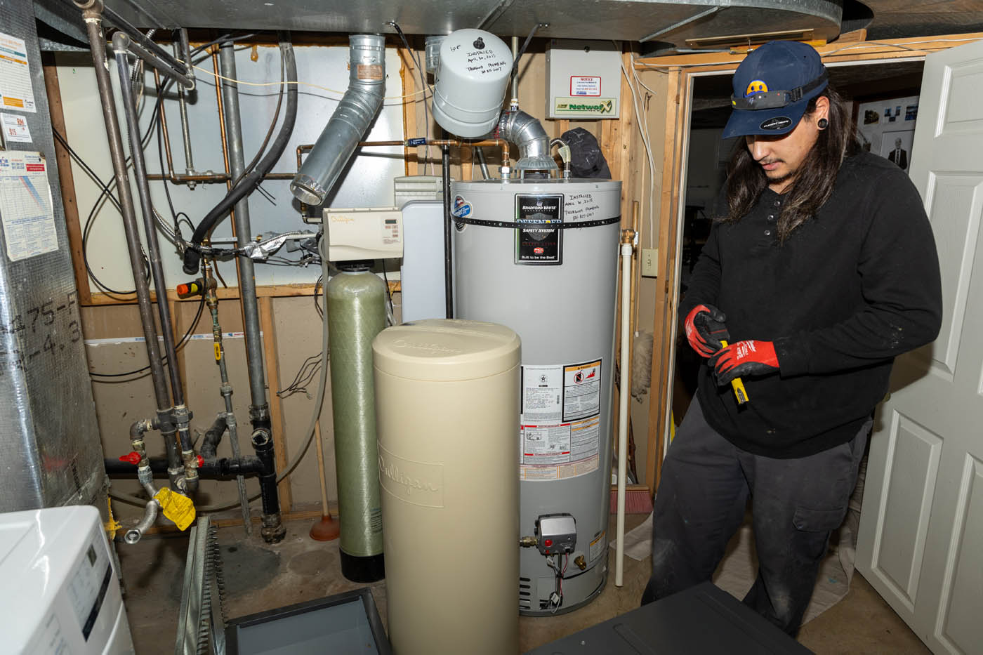A Absolute Comfort Heating and Air Conditioning technician working on a water heater service.