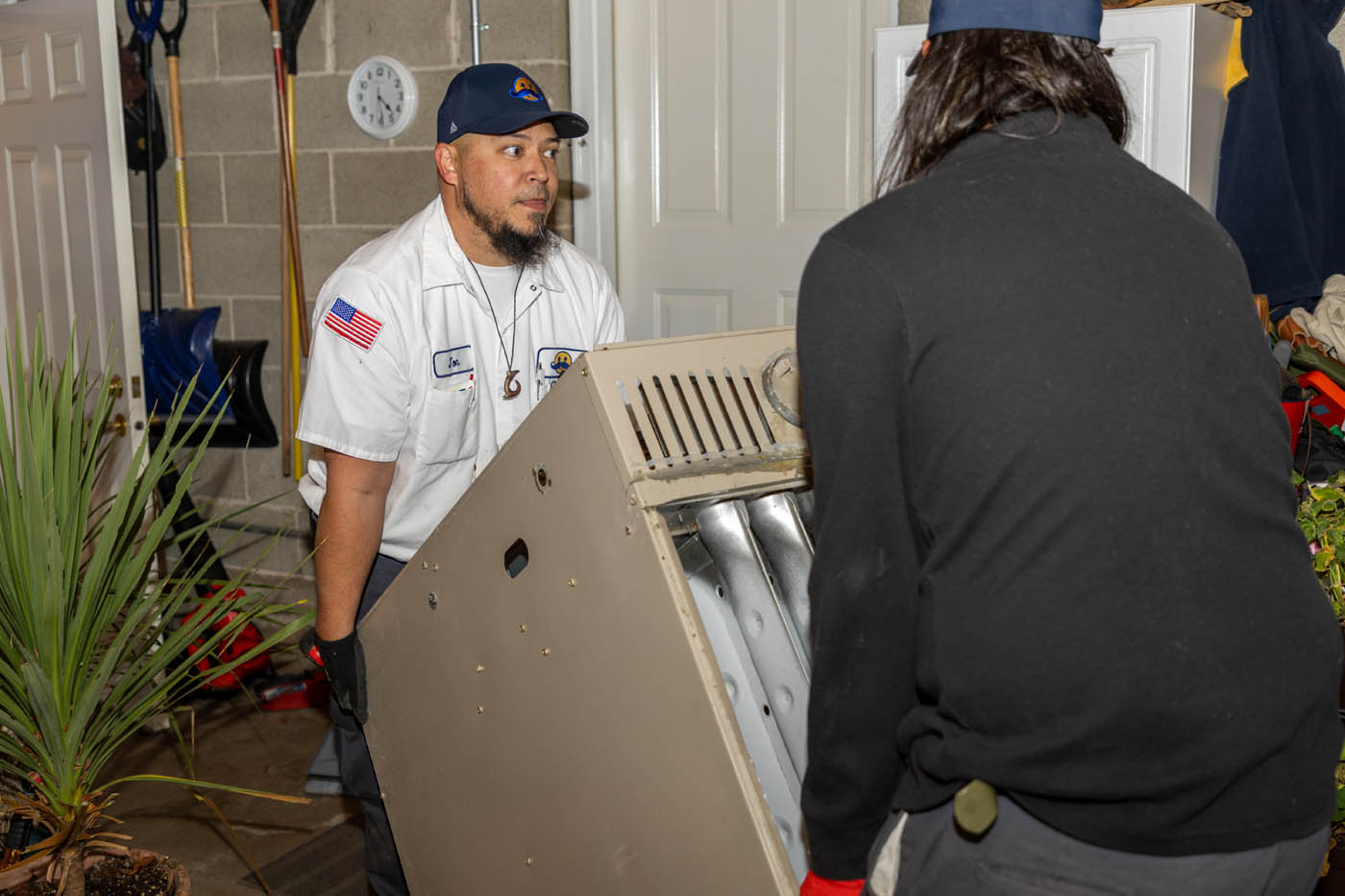 Absolute Comfort technicians moving equippment - learn what makes us the best heating company.