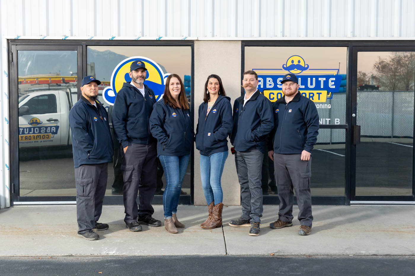 The Absolute Comfort team standing in front of our company's storefront - contact us today for a free estimate!