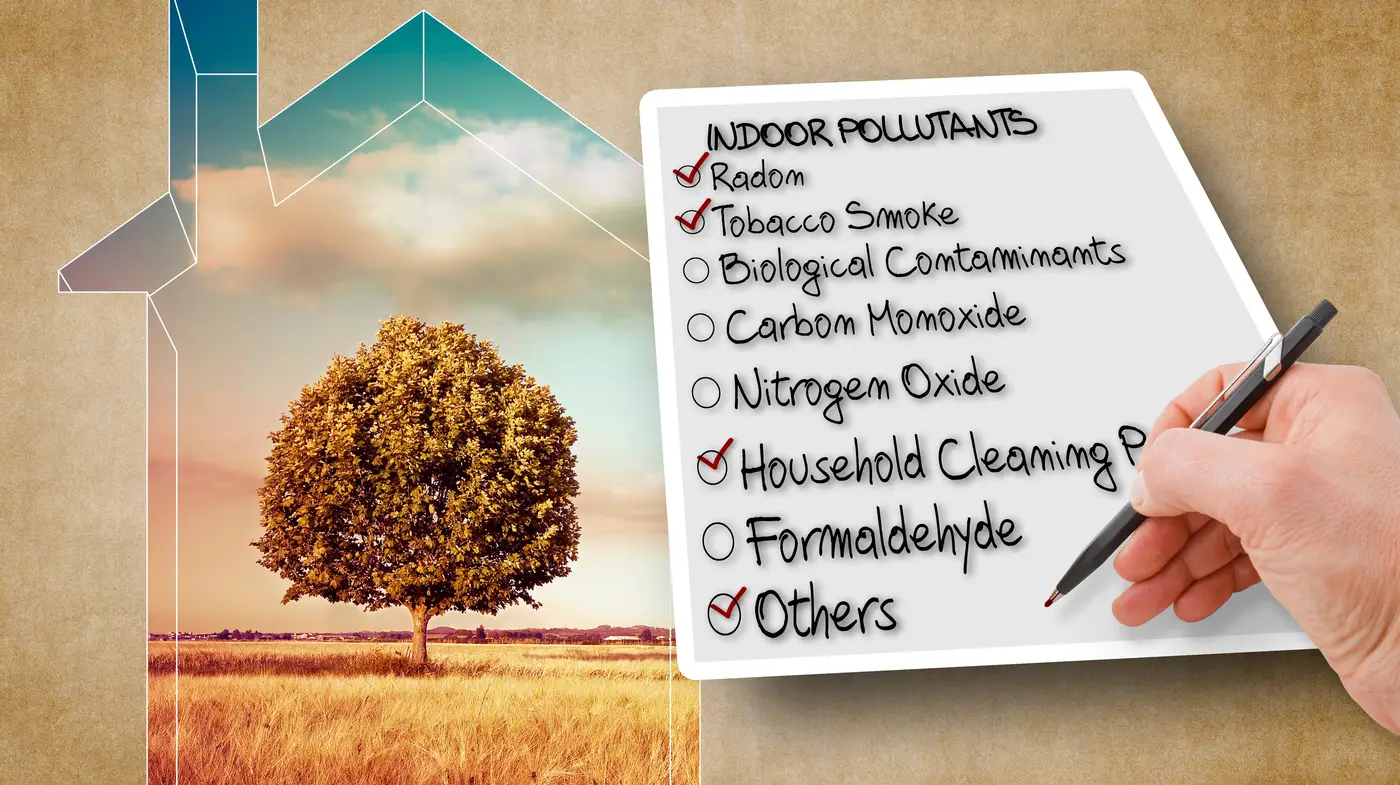 Absolute Comfort’s image of a home and a tree in the background, with a hand holding a pen in the foreground checking off a list of indoor pollutants for South Ogden, UT, pollutants listed are: Radon, tobacco smoke, biological contaminants, carbon monoxide, nitrogen oxide, household cleaning products, formaldehyde, and others