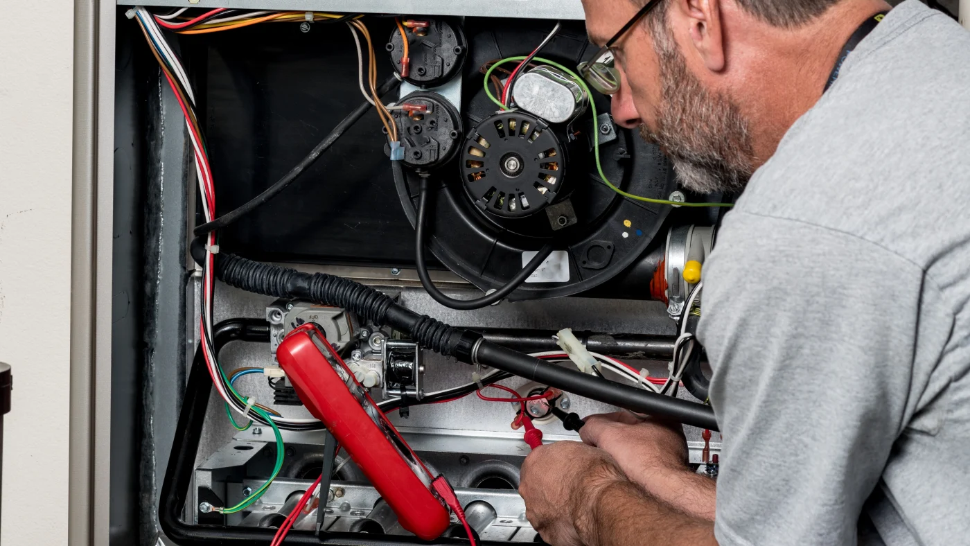 Furnace in an Ogden, Utah home being repaired by a technician from Absolute Heating & Air Conditioning
