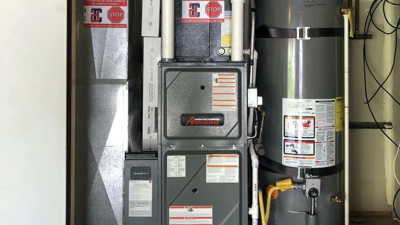Happy Absolute Comfort Heating & Air Conditioning customer adjusts thermostat in Ogden, UT home